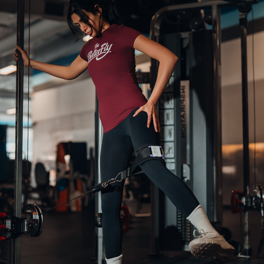 Person exercising on a cable machine in a gym setting