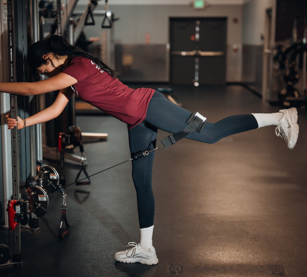 woman performing glute exercise with knee loaded attachment