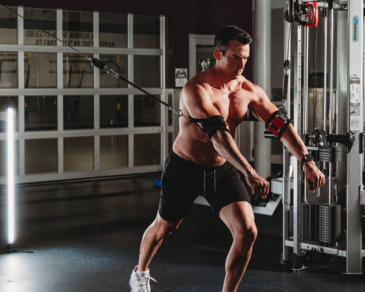 Muscular man exercising with resistance bands in a gym setting