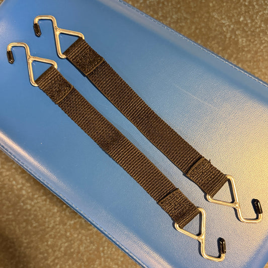 Brown strap with metal hooks on a blue surface