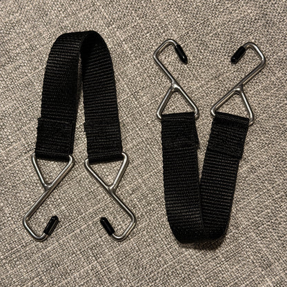Two black straps with metal hooks on a textured surface