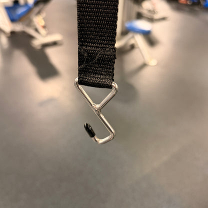 Black strap with a metal hook on a gray surface
