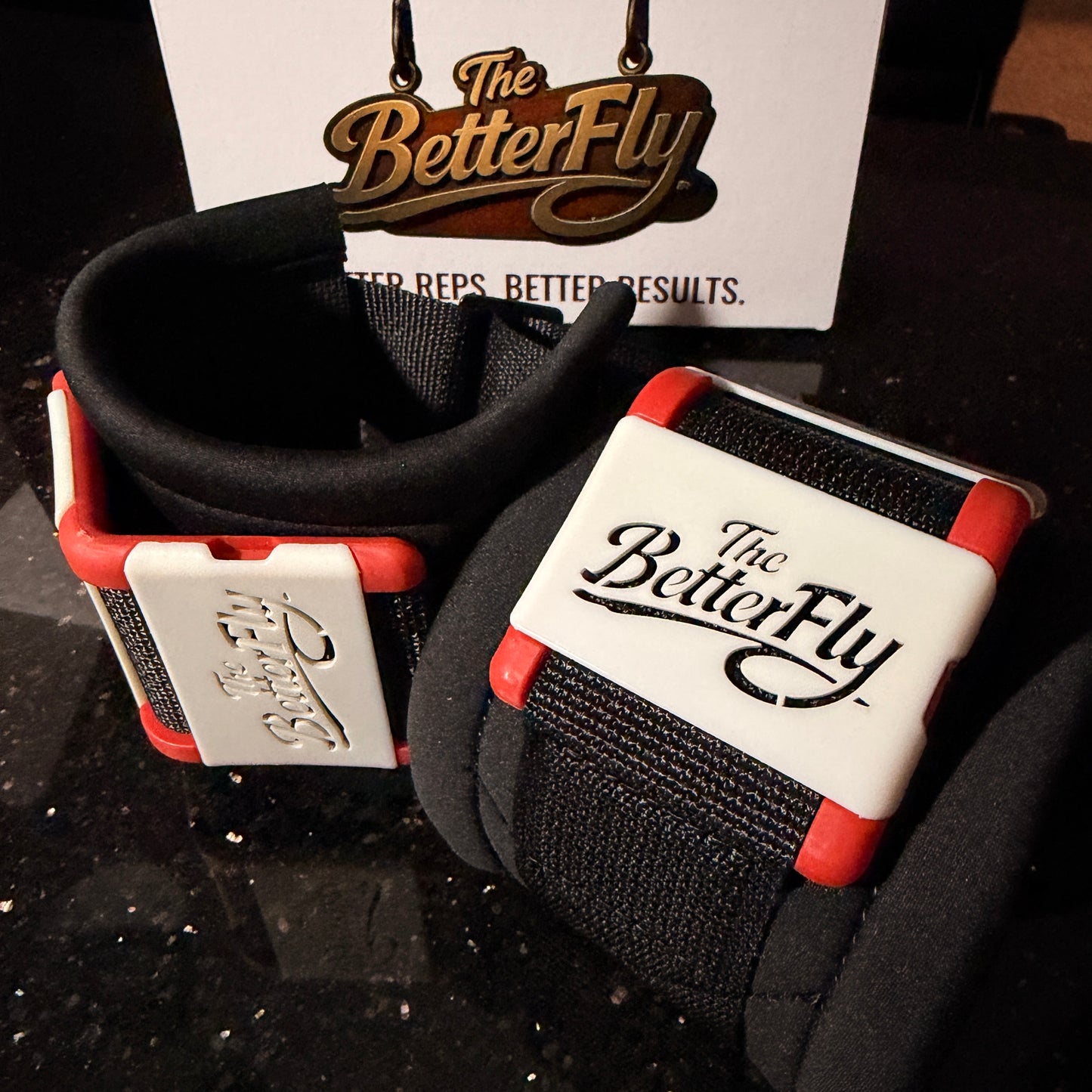 Black and red wrist wrap with 'The Better Fly' branding on a dark surface.