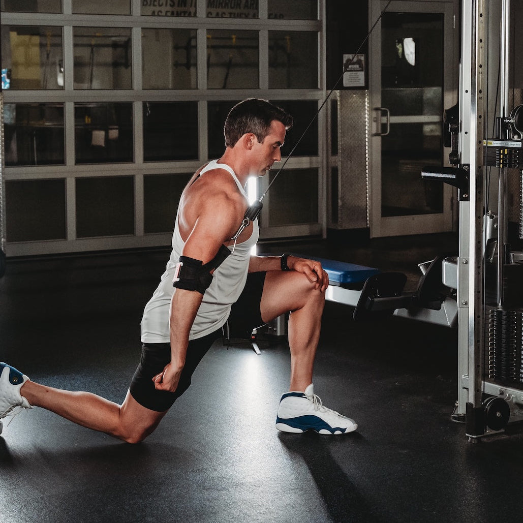 Man performing cable arm workout with gym cuff attachment