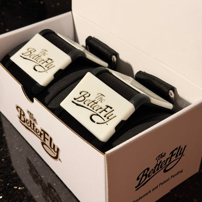 Two black and white straps with 'The Better Fly' branding in a box.